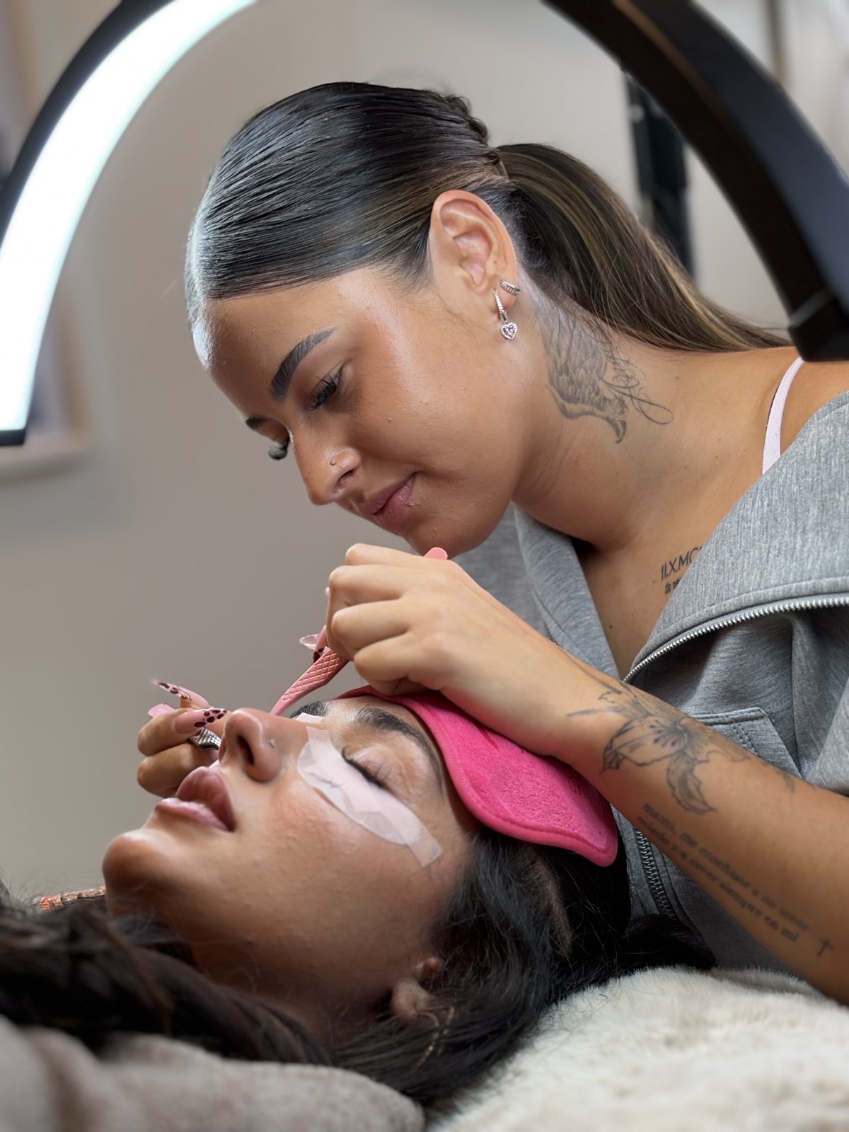 Emili réalisant une pose d'extensions de cils au studio Lashmood, Genève